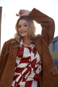 Mollie Pearce posing in a brown suede jacket