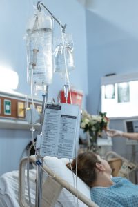 A female patient looks away from camera in her hospital bed