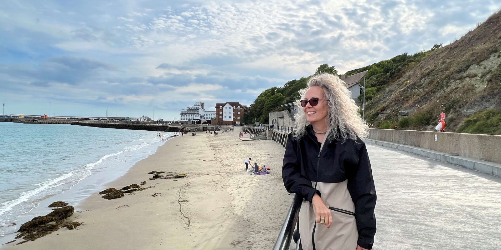 Raphaela Reeb, a former air steward and ostomate, looks over a sandy beach from a promenade.
