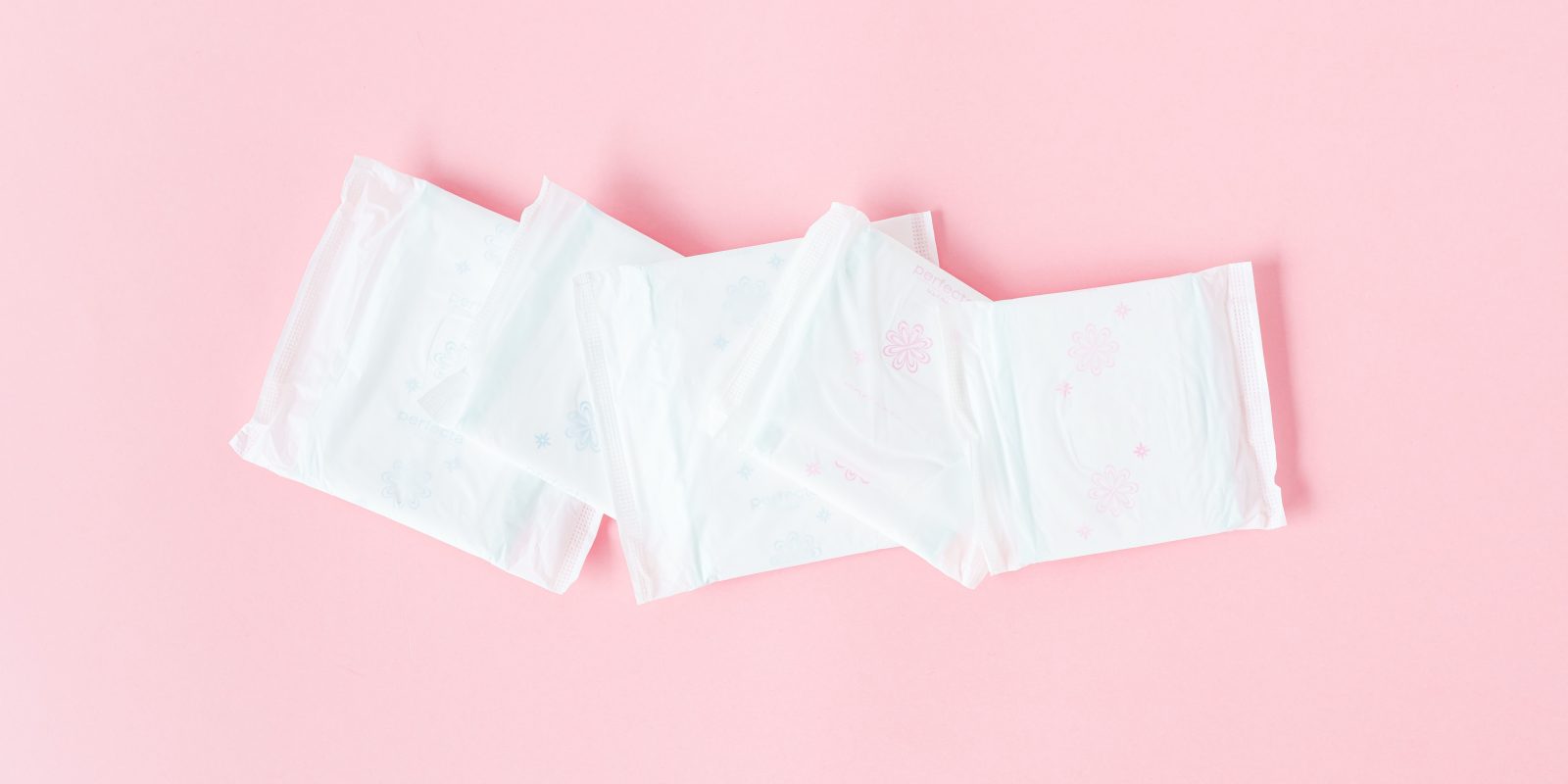 Close-up of sanitary towels on a pastel pink background for menstrual hygiene.